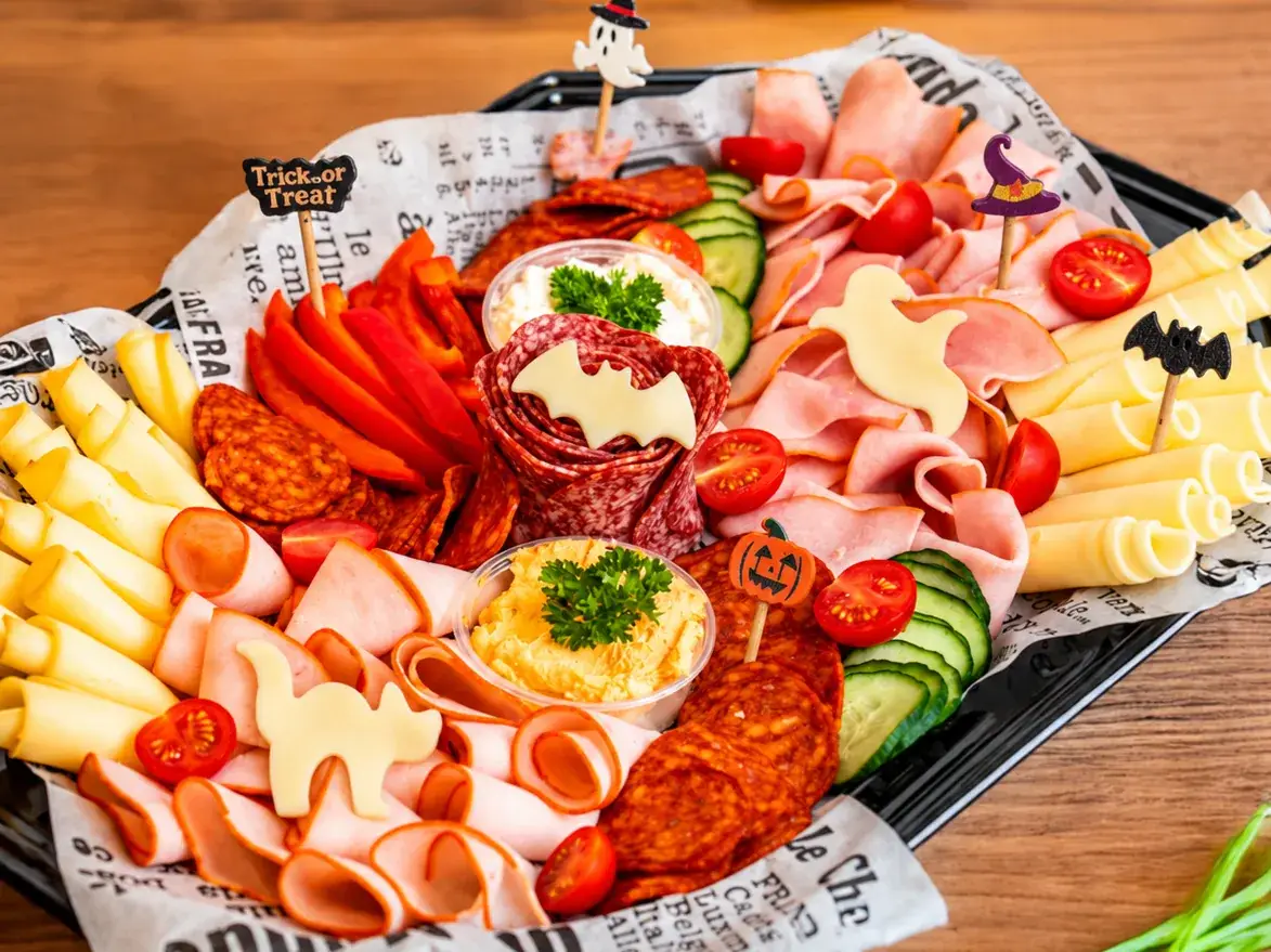 Céges Halloween catering 2026 Delikárhozat tál: felvágottak, sajtok és friss zöldség, sajtból vágott denevérrel és szellemmel